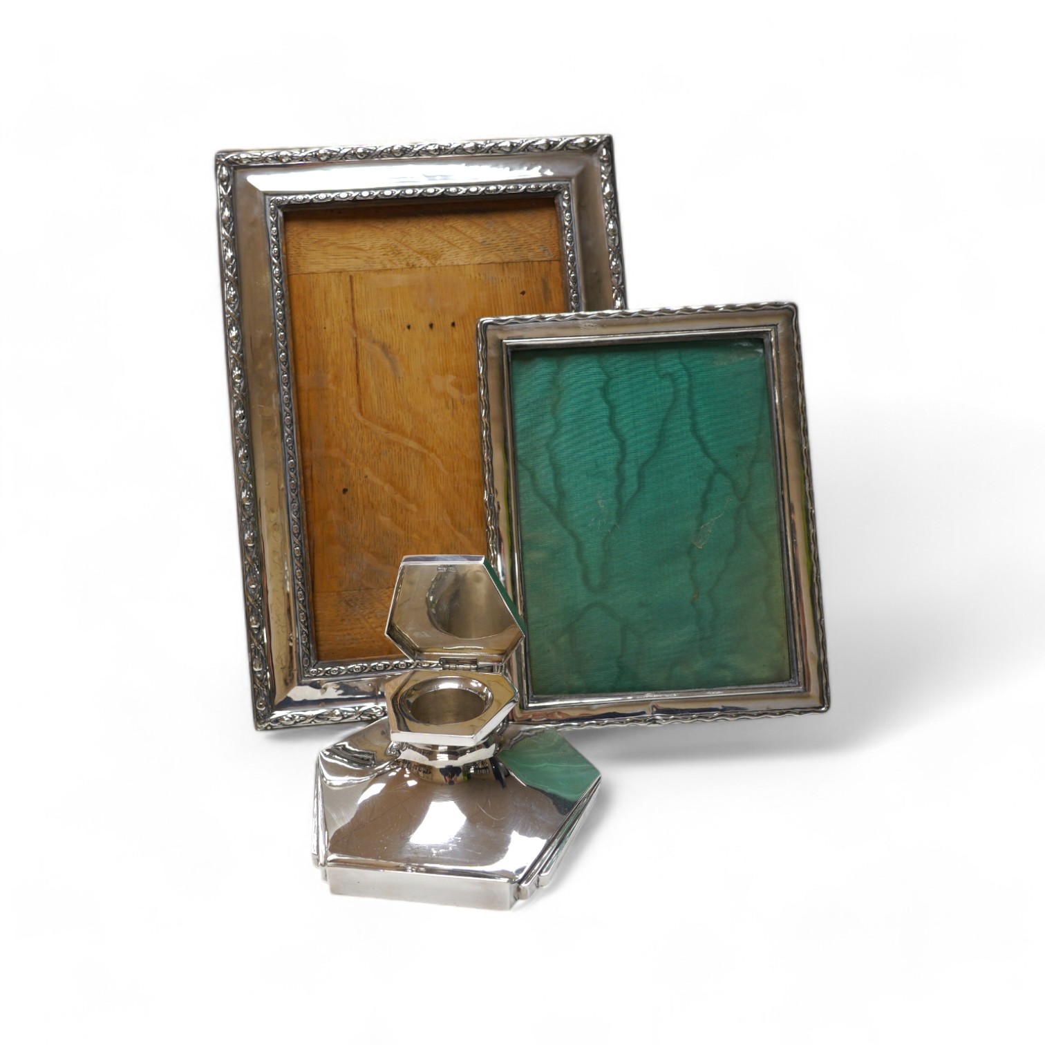 A George VI Art Deco silver mounted inkwell, Sheffield, 1949, 15.1cm and two early 20th century silver mounted rectangular photograph frames, largest 34.2cm. Condition - poor to fair